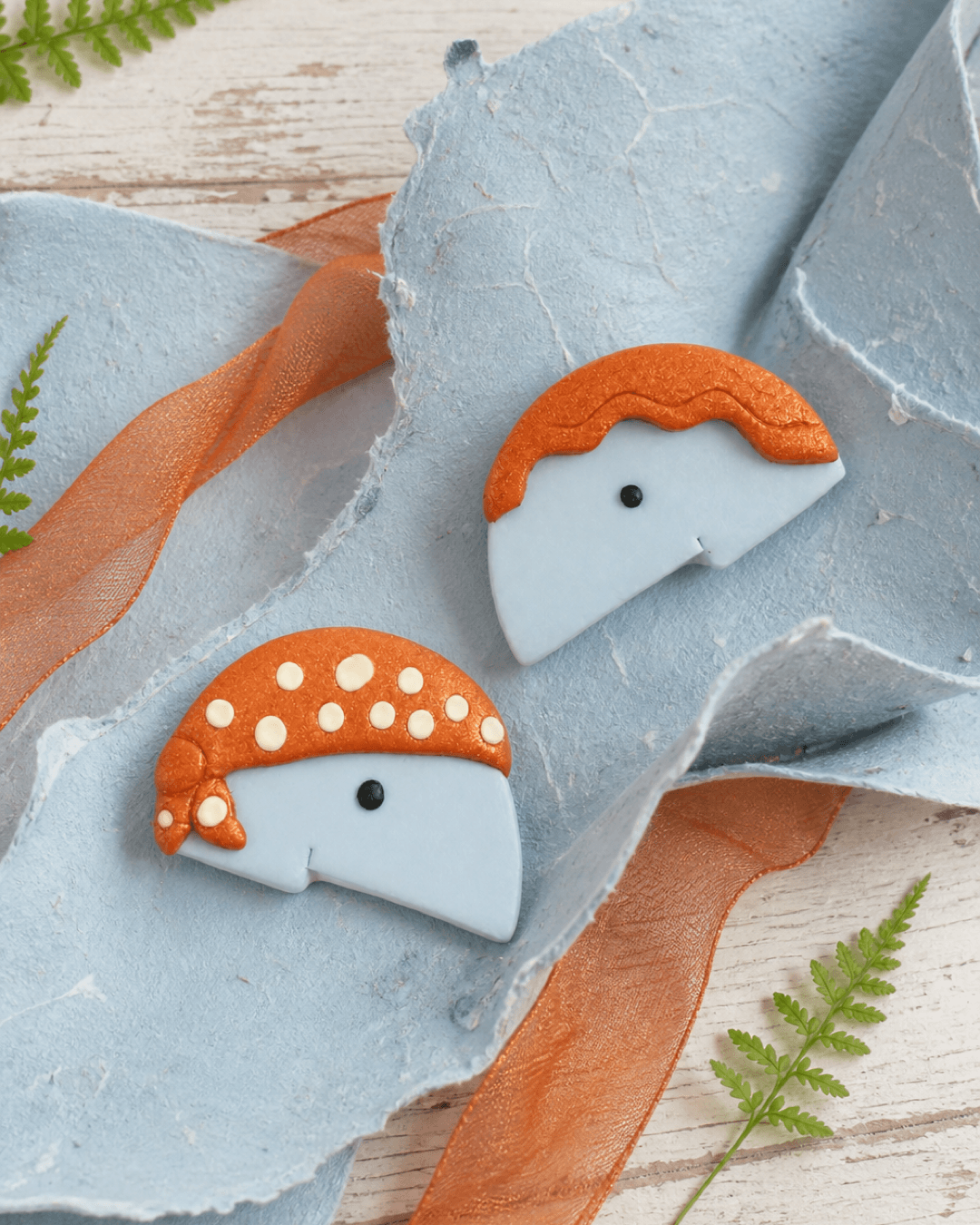 Mushroom character studs arranged with warm paper and natural studio materials